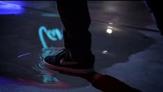 a person standing on the ground with their feet in the air and lights reflecting off them