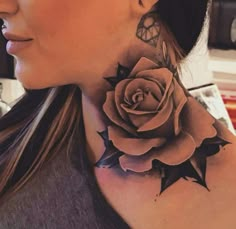 a woman with a tattoo on her neck and behind her ear is a large rose