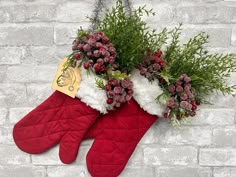 two christmas stockings with flowers and greenery hanging from them