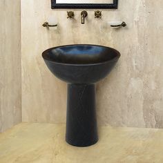 a black sink sitting under a bathroom mirror next to a wall mounted faucet