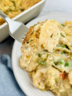 a white plate topped with broccoli casserole next to a serving dish