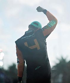 a man with his arm up in the air holding a frisbee and wearing a helmet