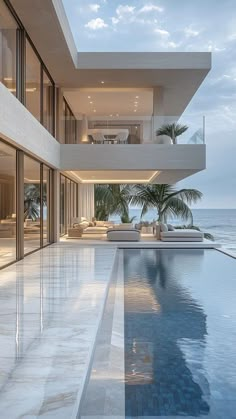 a large swimming pool in front of an ocean view house