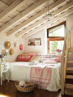 a bed sitting under a wooden ceiling next to a window