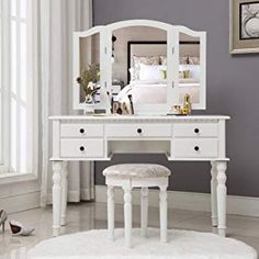 a white dressing table with stool and mirror