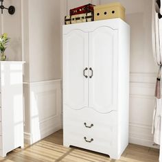 a white armoire in a room with wood floors