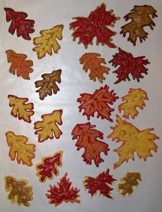 a bunch of leaves that are sitting on a sheet of paper with some brown and orange colors