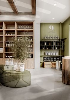 an empty room with shelves and bottles on the wall, in front of a glass coffee table