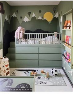 a child's bedroom with green walls and white furniture, including a crib