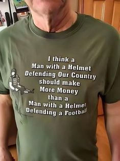 a man wearing a t - shirt that reads i think a man with a helmet defending our country should make more money than a man with a helmet