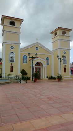 a large yellow building with two clocks on it's sides and an entrance way