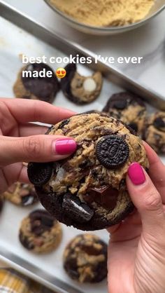 a woman holding an oreo cookie in her hand