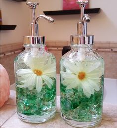 two soap dispensers with flowers in them