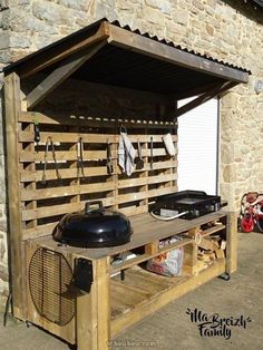 an outdoor bbq grill built into the side of a building with wood pallets