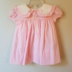 "- This gorgeous vintage dress is ready to be worn again! It is pink gingham with short sleeves and buttons at back of neck. There is a large, round collar trimmed in gingham ruffles. The white on collar is embroidered with pink flowers with greens and a bow. So perfect for Easter. size is: 9 months (2 available) Length: 13.75\" + 3\" hem allowance" Classic Gingham Dress With Short Sleeves, Cute Short Sleeve Plaid Dress For Picnic, Cute Plaid Short Sleeve Dress For Picnic, Cute Gingham Dress With Short Sleeves, Preppy Short Sleeve Dress For Picnic, Classic Gingham Cotton Dresses, Pink Short Sleeve Dress For Picnic, Classic Pink Cotton Dress, Sweet Gingham Dress With Ruffles