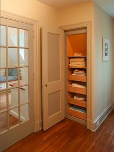 an empty room with wooden floors and white doors