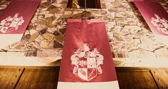 several red and white banners hanging from the side of a stone wall next to a doorway