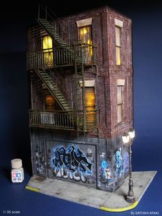 a model of a brick building with graffiti on the side and stairs up to it