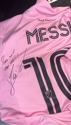 a pink soccer jersey with the number ten on it and signed autographs in front