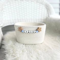 a white basket with the word mama written on it, sitting on a fluffy rug