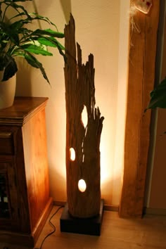 a lamp that is on top of a table next to a potted plant in a room