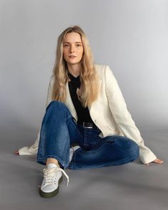 a woman sitting on the ground with her legs crossed