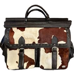 a brown and white cow print bag with two compartments