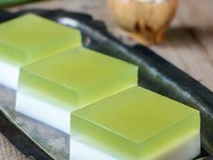 three squares of green and white soap on a tray