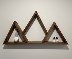 two wooden shelves with three triangulars on them