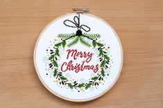 a cross stitch christmas ornament hanging on a wooden surface