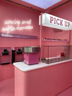 a pink ice cream shop with neon signs above the counter and lights on the wall