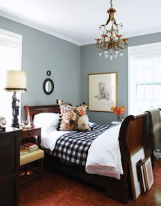 a bed room with a neatly made bed and a chandelier