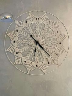 a clock that is on the wall with numbers and an image of a doily