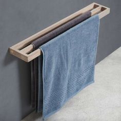 a towel rack with two blue towels hanging from it's sides on the wall