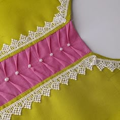 a yellow and pink dress with white lace