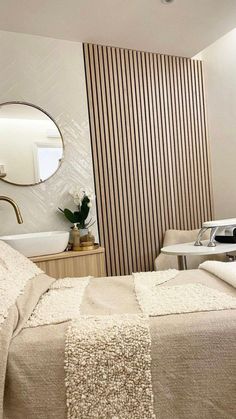 a bed sitting next to a bathroom sink under a mirror on top of a wall