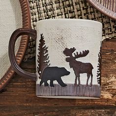 a coffee cup with a moose and bear design on it