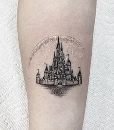 a castle tattoo on the right thigh with a crescent moon above it and stars in the sky