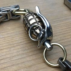 a pair of metal handcuffs sitting on top of a wooden table next to a keychain