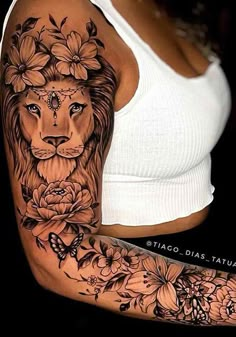 a woman's arm with a lion and flowers tattoo on her left arm, which is covered in black ink