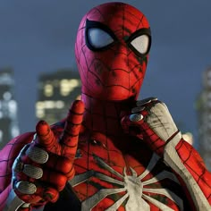 the spider - man is standing in front of a cityscape and pointing to something