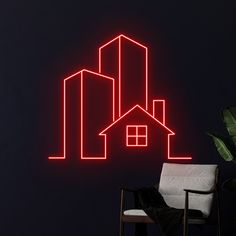 a neon sign that is on the wall next to a chair and potted plant