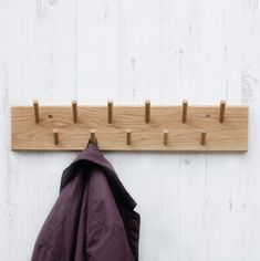 a coat rack with two coats hanging from it's hooks on a white wall