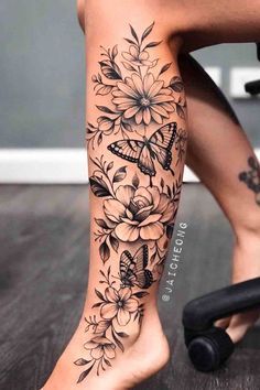 a woman's leg with flowers and butterflies on it