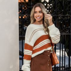 Embrace cozy chic style with this striped balloon sleeve sweater. Crafted from a soft knit material, it features a relaxed silhouette with voluminous balloon sleeves for a touch of effortless glamour. The color palette blends warm beige with rich burnt orange stripes, creating an autumnal vibe that transitions seamlessly from season to season. The slightly cropped length pairs perfectly with high-waisted bottoms like the corduroy skirt shown. Versatile enough for laid-back weekends or elevated c Drop Sleeve Sweater, Balloon Sleeve Sweater, Cozy Fall Outfits, Warm Beige, Drop Shoulder Sweaters, Corduroy Skirt, Cozy Chic, Cozy Knits, Cozy Fall