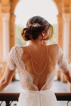 the back of a woman in a wedding dress looking off into the distance with her hand on her shoulder