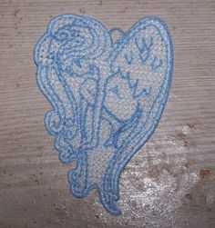 an embroidered heart on a piece of wood