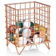 a metal basket filled with lots of different types of balls and tins in it