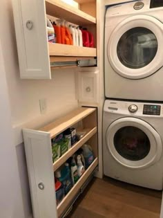 a washer and dryer in a small room next to each other with shelves