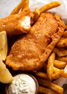 fried fish and fries with lemon wedges on the side